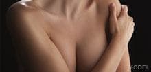 Breast augmentation model with arms crossed over body