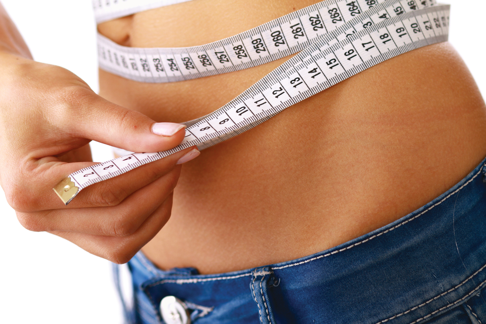 woman measuring waistline