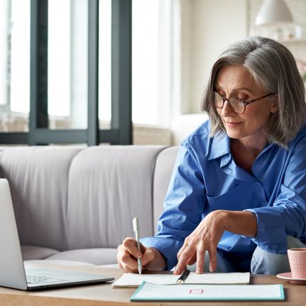 Woman watching webinar on laptop at home