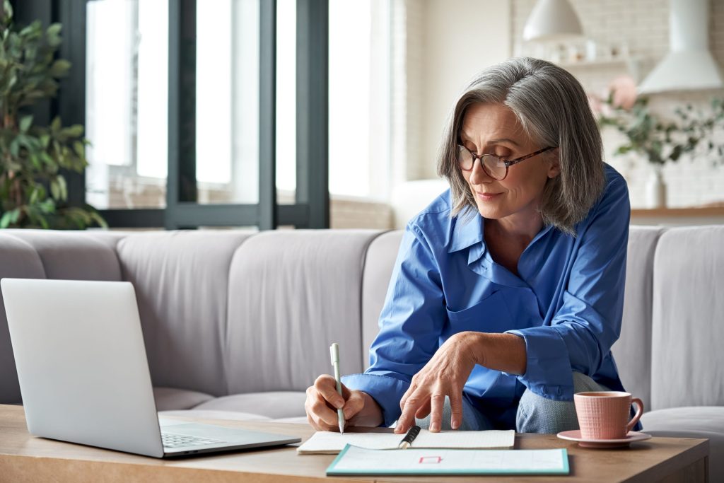 Woman watching webinar on laptop at home