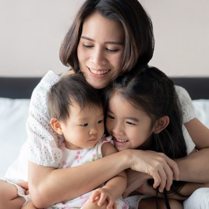 Mom hugging her two children