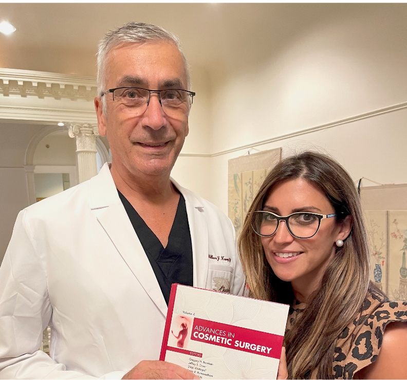 Dr. Koenig and Dr. Amalfi with a copy of the Advances in Cosmetic Surgery journal that includes their book chapters on breast augmentation and 360 abdominoplasty.