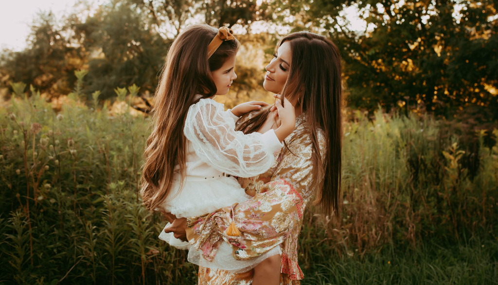 Dr. Amalfi holding her daughter, outside in a field