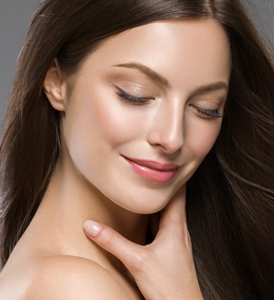 Model smiling touching chin